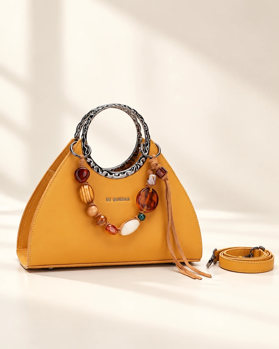 Model 3203, triangular bag with circular metal handles and beaded decoration, shown with a coiled shoulder strap.